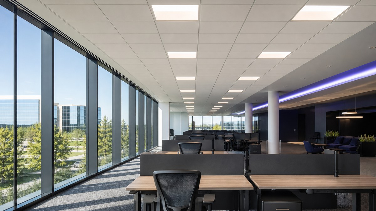 Open office workstations near floor-to-ceiling windows with daylight harvesting LED lighting controls in a Plano office tower