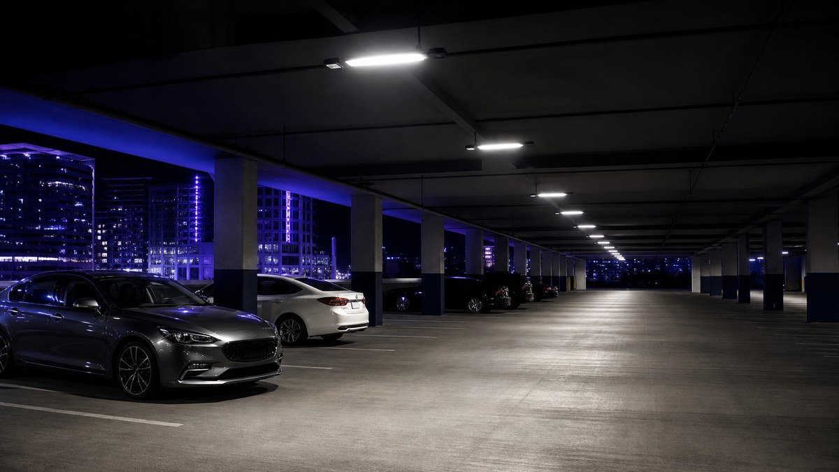 Office building parking garage in Plano Texas with LED fixtures and occupancy-based lighting controls at night